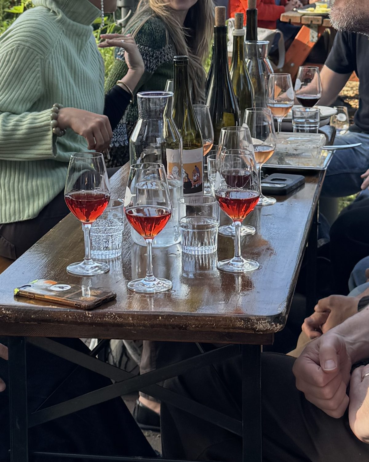 Groep met glazen natuurwijn op het terras van Zuiver Bar