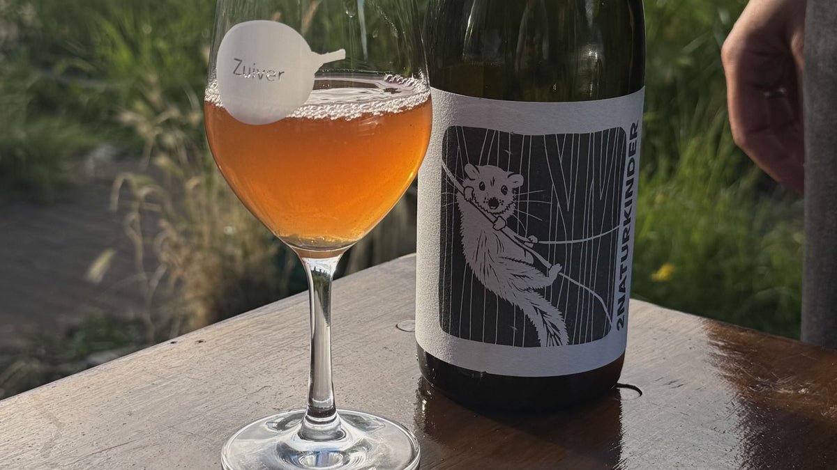 Glas natuurwijn met fles buiten bij Zuiver Bar